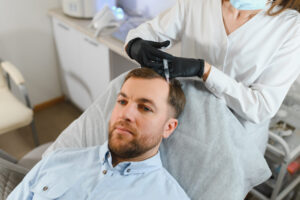 Nicht-operative PRP Behandlung der Kopfhaut bei einem Mann in medizinischer Umgebung