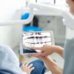 Zahnärztin mit Röntgenbild und Patienten